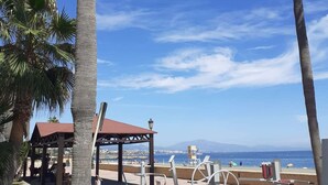 A beachside park with exercise equipment, a gazebo, and palm trees. - 3 bedroom apartment in San Luis de Sabinillas (San Luis de Sabinillas)