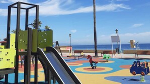 A playground with a slide, climbing structures, and colorful play area. - 3 bedroom apartment in San Luis de Sabinillas (San Luis de Sabinillas)