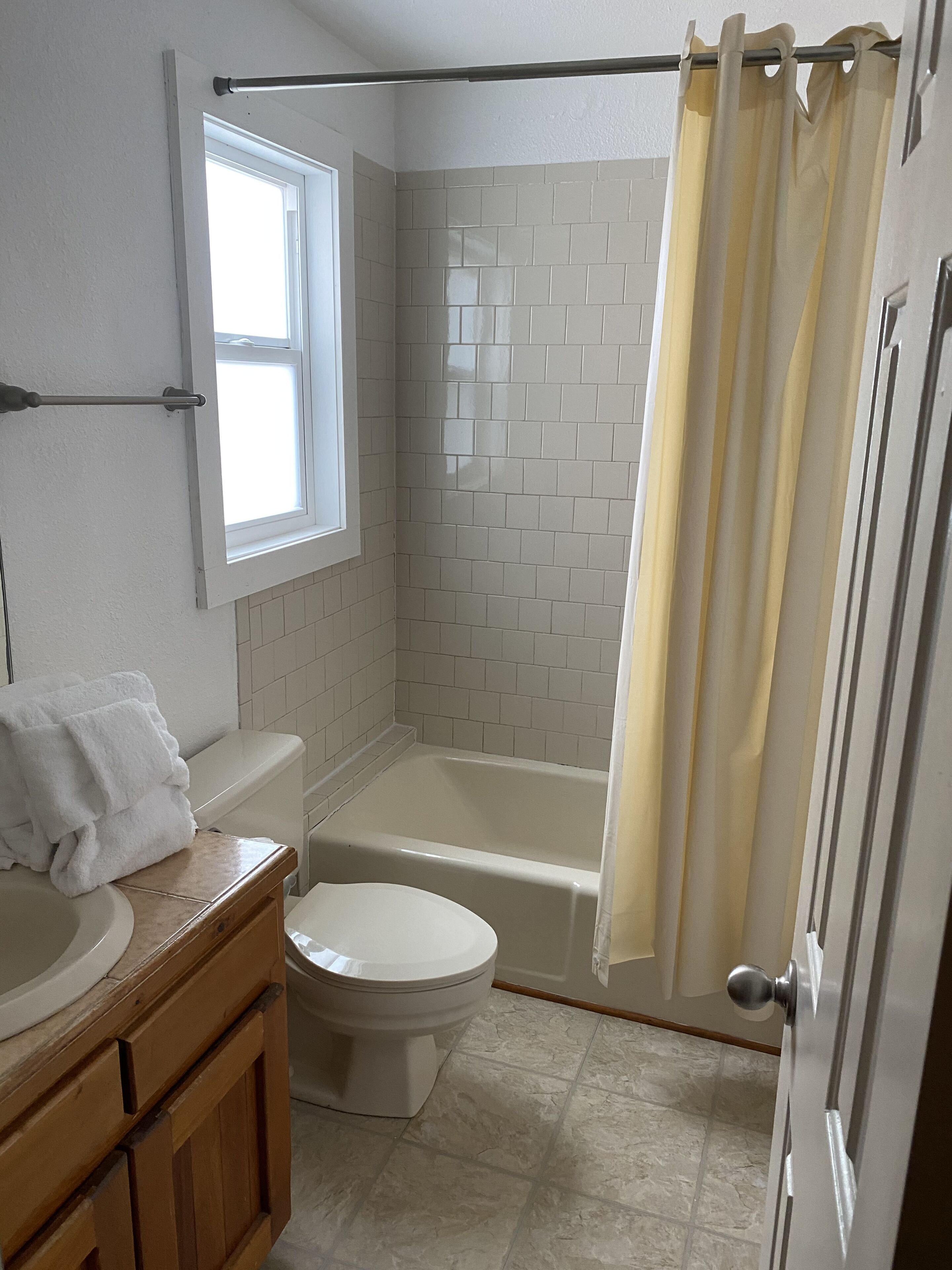 A bathroom with a toilet, sink, and bathtub.