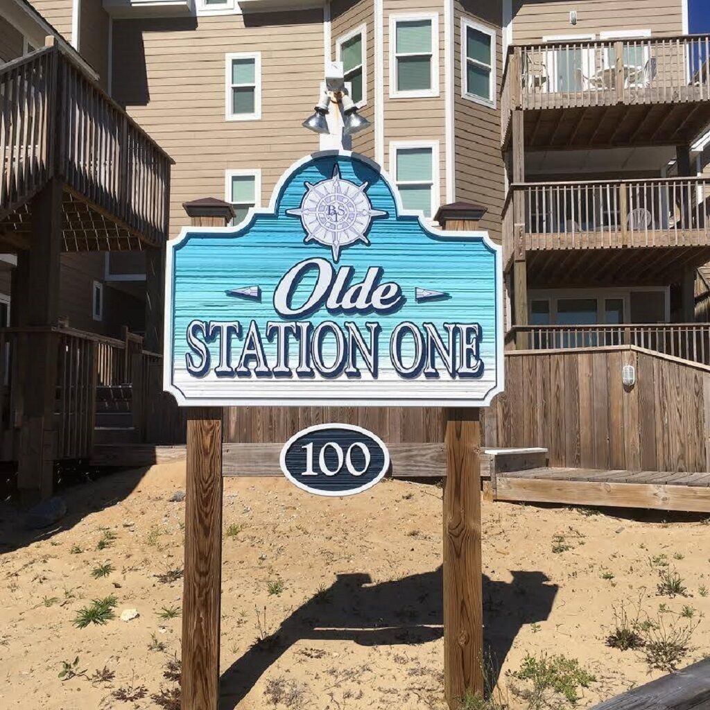 Ein Schild für Olde Station One, ein hölzernes Gebäude mit Balkon und einem kreisförmigen Wappen.