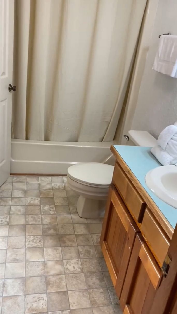 A bathroom with a bathtub, toilet, and sink.