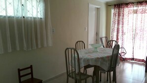 A dining area with a table set for four, surrounded by chairs.