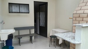 A compact kitchen with a sink, bench, and small table.