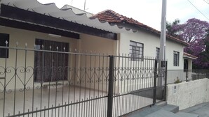 A residential building with a tiled roof, a gated entrance, and a concrete wall.