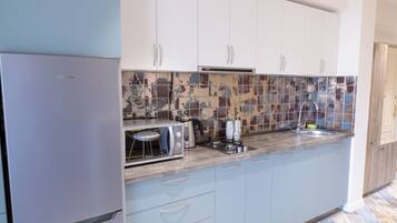 Een koelkast, een microgolfoven, kookgerei, borden en bestek