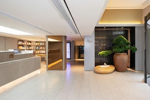 A modern reception area with a counter, bookshelves, and a digital display. - Ji Hotel (Shanghai Longyang Road Magnetic Levitation) (Shanghai)