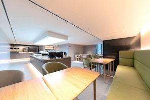 A modern hotel lobby with a kitchen area, seating arrangements, and a large window providing natural light. - Ji Hotel (Shanghai Longyang Road Magnetic Levitation) (Shanghai)