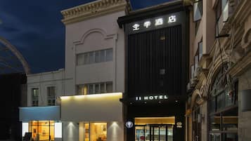 A hotel with a modern facade, a prominent entrance, and a sign indicating it is a hotel.
