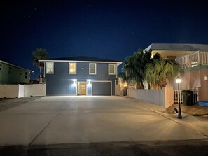 A two-story house with a garage, a driveway, and a well-lit entrance.