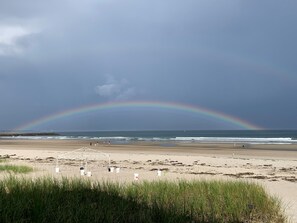 A beach with a rainbow, a white structure, and some people. - Coastal cottage w/views - newly decorated - 1 min walk to beautiful Wells Beach! (Wells)