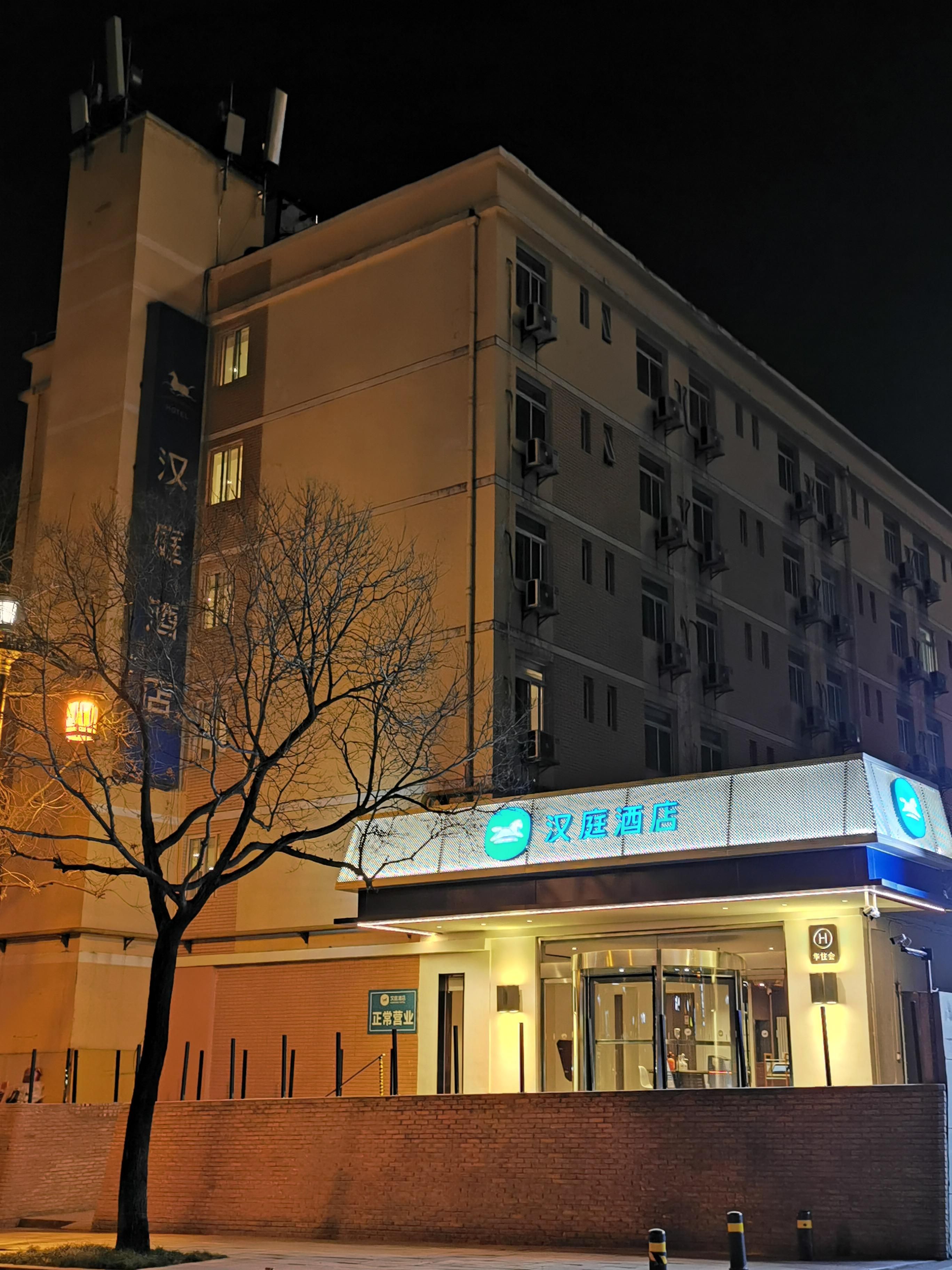 A hotel with a sign indicating '汉庭酒店' and a visible entrance.