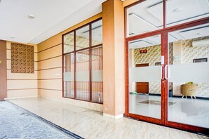 A hotel lobby with a tiled floor, a reception desk, and a wall-mounted clock. - Hotel O Sean's Residence Mansyur Near USU (Medan)