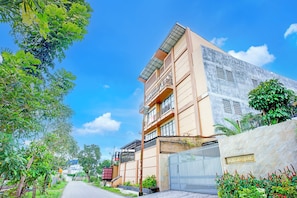 A multi-story building with balconies, a gated entrance, and a clear sky. - Hotel O Sean's Residence Mansyur Near USU (Medan)