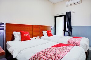 A hotel room with two beds, each with white bedding and red accents, a wooden headboard, and a window with a curtain. - Hotel O Sean's Residence Mansyur Near USU (Medan)