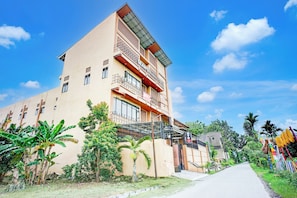 A multi-story building with balconies, a gated entrance, and a clear sky. - Hotel O Sean's Residence Mansyur Near USU (Medan)