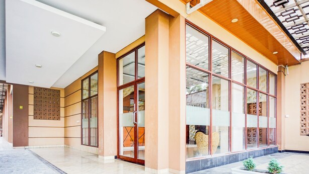 A modern hotel lobby with large glass doors, a marble floor, and a wooden ceiling. - Hotel O Sean's Residence Mansyur Near USU (Medan)