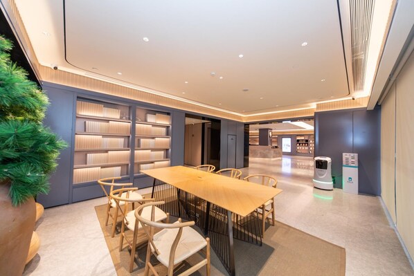 A modern conference room with a long table, chairs, and bookshelves. - Ji Hotel (Xi'an)