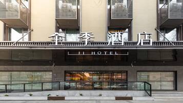 A hotel with a modern facade, large windows, and a visible entrance.