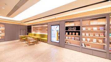 A modern bookstore interior with a seating area, bookshelves, and a digital display.