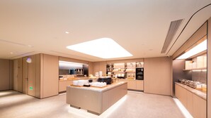 A modern hotel kitchen with a central island, built-in appliances, and a clean, minimalist design. - Ji Hotel (Xi'an)