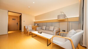 A modern hotel room with a sofa set, two armchairs, a coffee table, and a lamp. - Ji Hotel (Xi'an)