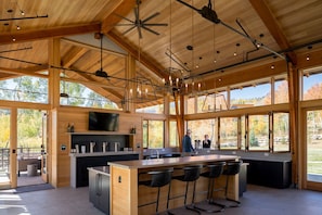 A spacious kitchen with a large island, bar stools, and a TV mounted above the counter.