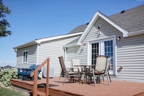 A house with a covered patio, outdoor seating, and a small table.