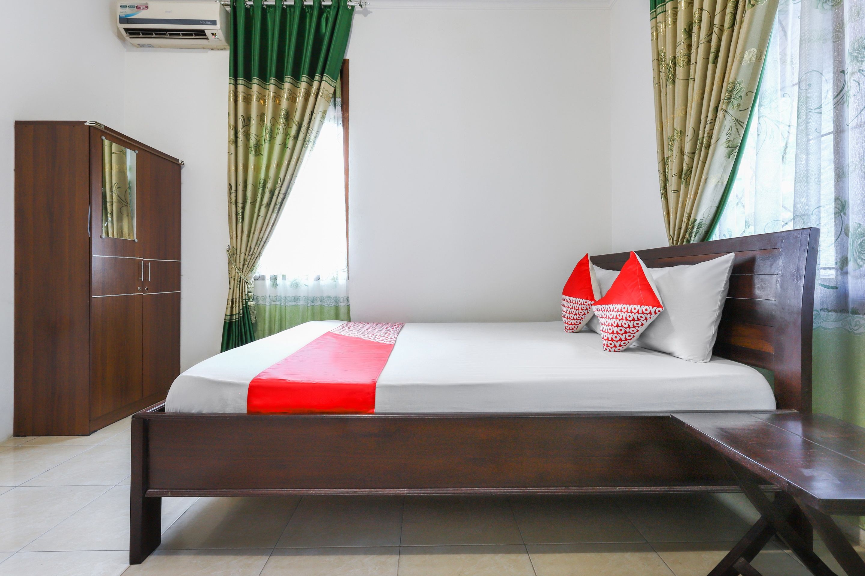 A bedroom with a bed, a wardrobe, and curtains.
