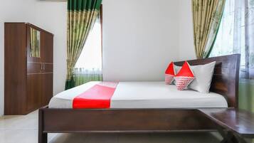 A bedroom with a bed, a wardrobe, and curtains.