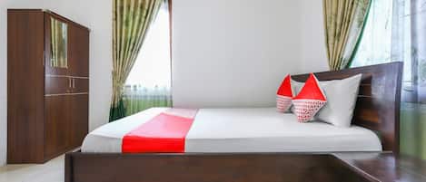 A bedroom with a bed, a wardrobe, and curtains.