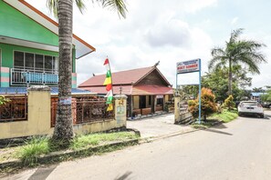 Un bâtiment à la façade verte, au toit rouge et à l’enseigne indiquant un forfait touristique intitulé « BUIK SOMBER ».