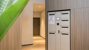 A hallway with a modern elevator, a wooden door, and a tiled floor. - Hanting Hotel Taizhou Jiaojiang Baolong City (Taizhou)