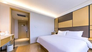 A hotel room with a bed, bedside table, and a desk with a chair. - Ji Hotel Nanjing Railway Station (Nanjing)