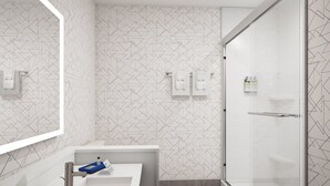 A modern bathroom with a geometric patterned wall, a white sink with a blue soap dish, and a glass shower enclosure. - Holiday Inn Express & Suites Lumberton by IHG (Lumberton)