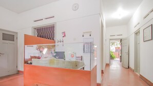 A hallway with a reception desk, a clock, and a calendar on the wall.