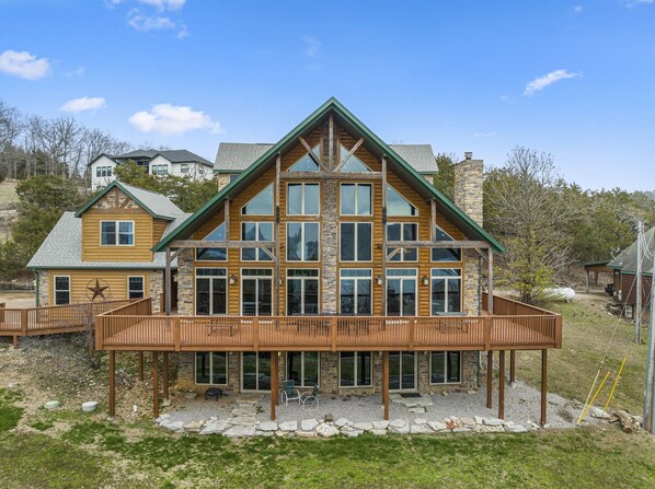 A large log cabin with a prominent central tower, multiple windows, and a covered porch area.