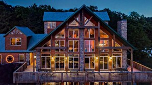 A large, multi-story log cabin with a prominent front porch and multiple windows. - Beautiful Views from the Rusty Moose (Branson West)