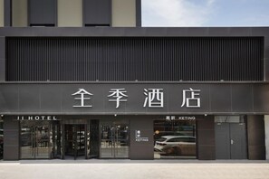 A hotel entrance with a modern facade, large glass doors, and signage indicating a KETING section. - Ji Hotel Beijing Jiuxianqiao 798 Art District (Beijing)