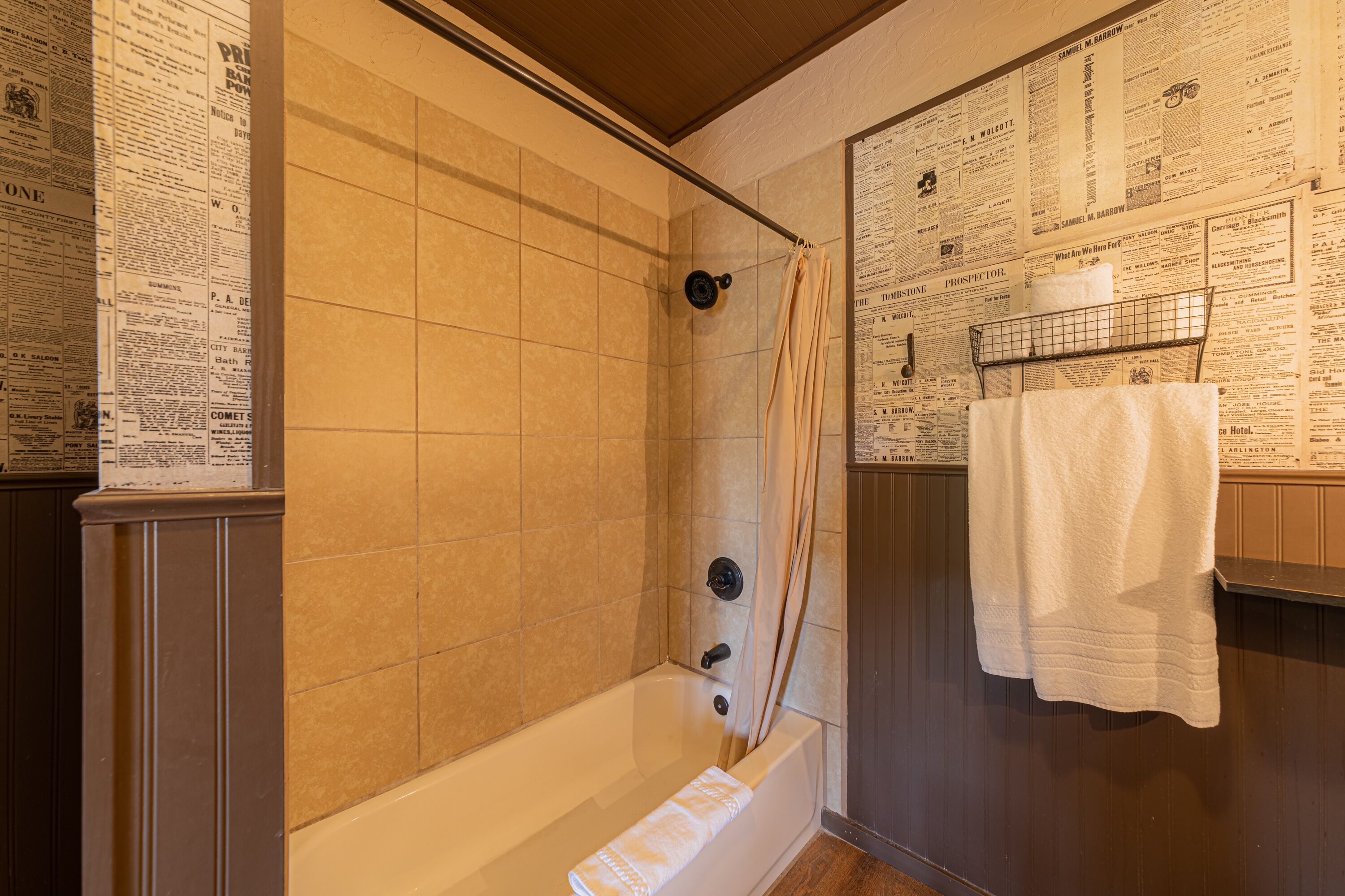 A bathroom with a bathtub, a shower curtain, and a towel rack with a white towel.