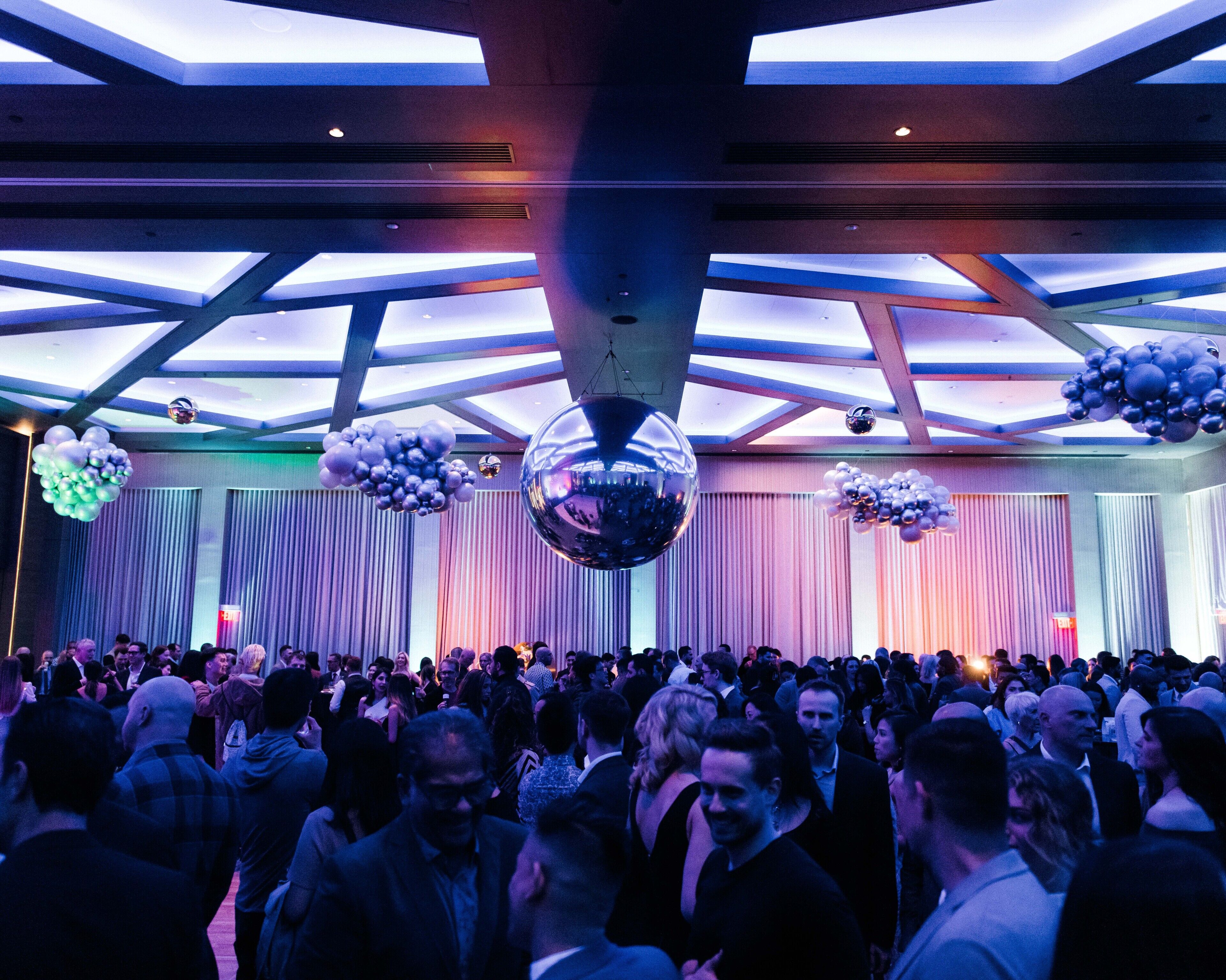 Un evento interior concurrido, con techos altos e iluminación moderna.