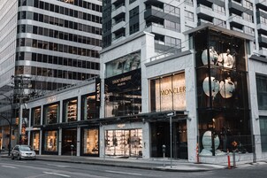 A multi-story building with storefronts including Prada and Saint Laurent.
