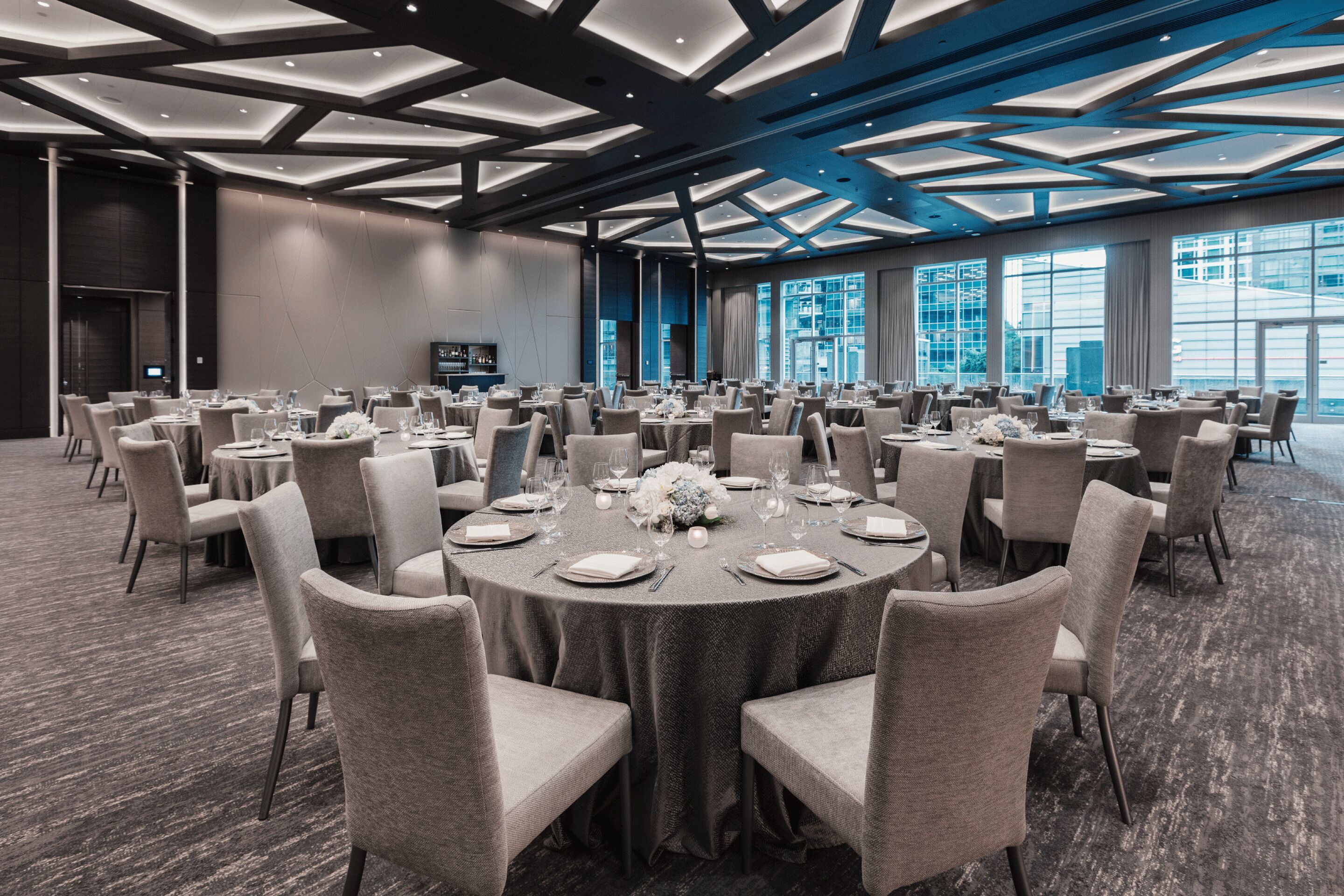 A conference room with round tables, chairs, and a modern ceiling design.