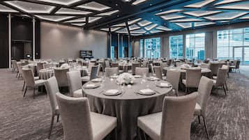 A conference room with round tables, chairs, and a modern ceiling design.