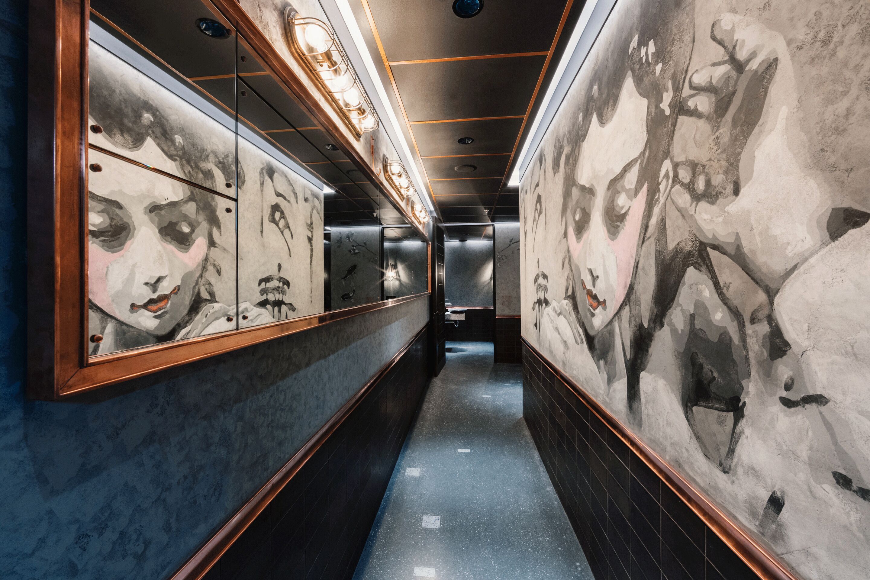 A hallway with mirrored walls and artwork.