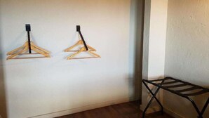 A room with two wooden wall-mounted drying racks and a black metal folding chair.