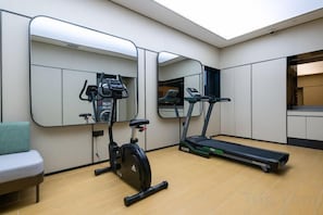 A gym with exercise equipment, a treadmill, and a mirrored wall. - JI Hotel (Shanghai Dongfang Yidecheng Luheng Road Metro Station) (Shanghai)