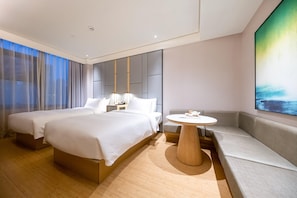 A modern hotel room with a large bed, a round table, and a seating area. - Ji Hotel (Shanghai)