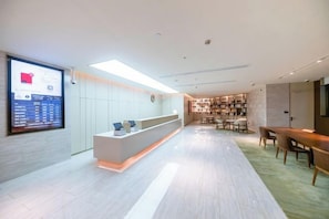 A modern hotel lobby with a reception desk, seating area, and a large digital display. - JI Hotel (Shanghai Dongfang Yidecheng Luheng Road Metro Station) (Shanghai)