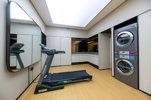 A modern bathroom with a treadmill, a washing machine, and a large mirror. - Ji Hotel (Shanghai)