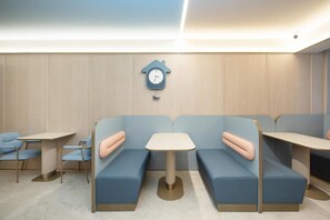 A modern interior with seating arrangements and a wall clock.
